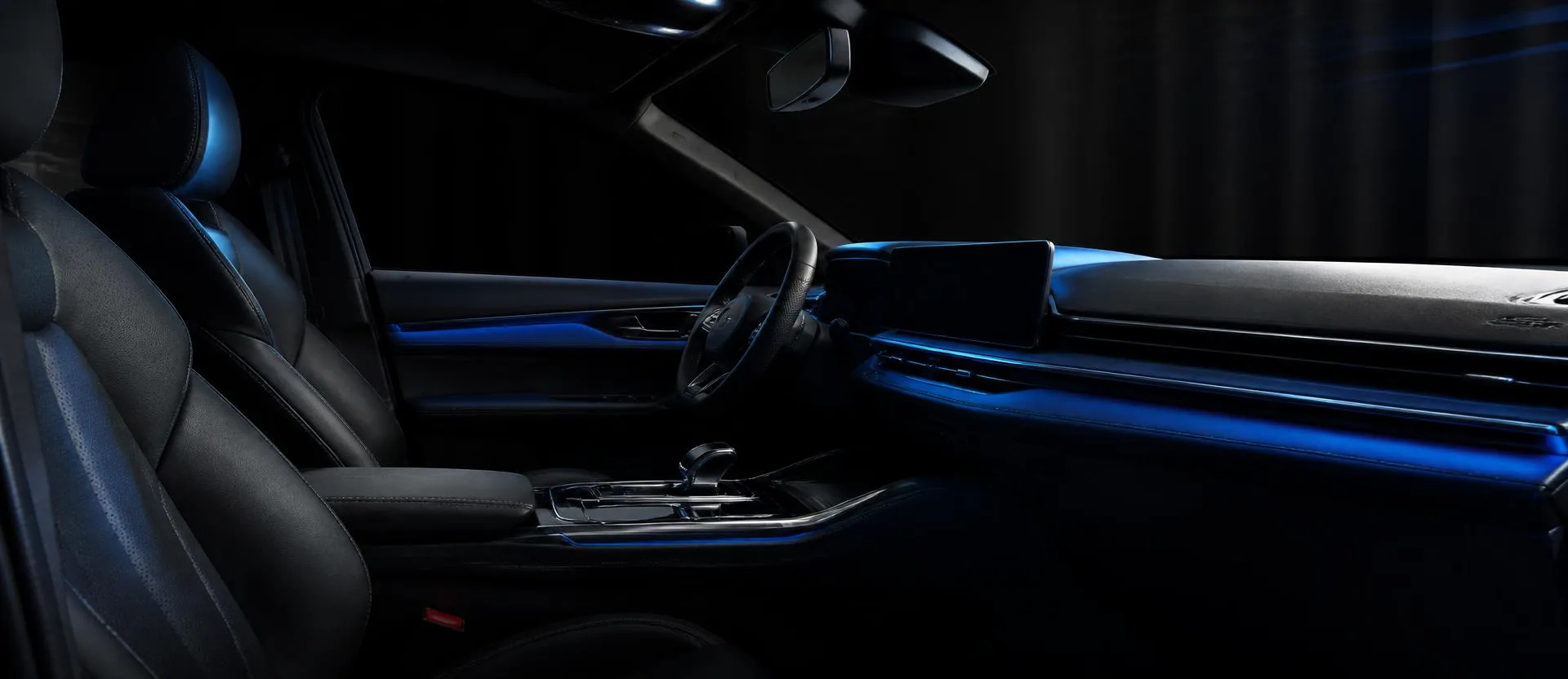 Wide view of a clean dark car cabin with blue ambient lighting after an Interior Mini detail