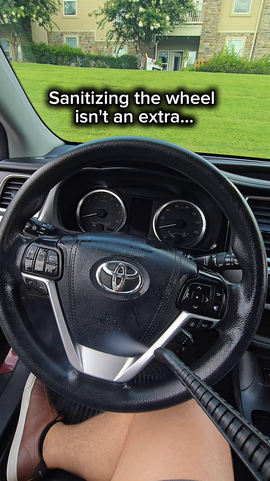 Grandett detailer using a steam tool on a vehicle steering wheel and interior surfaces