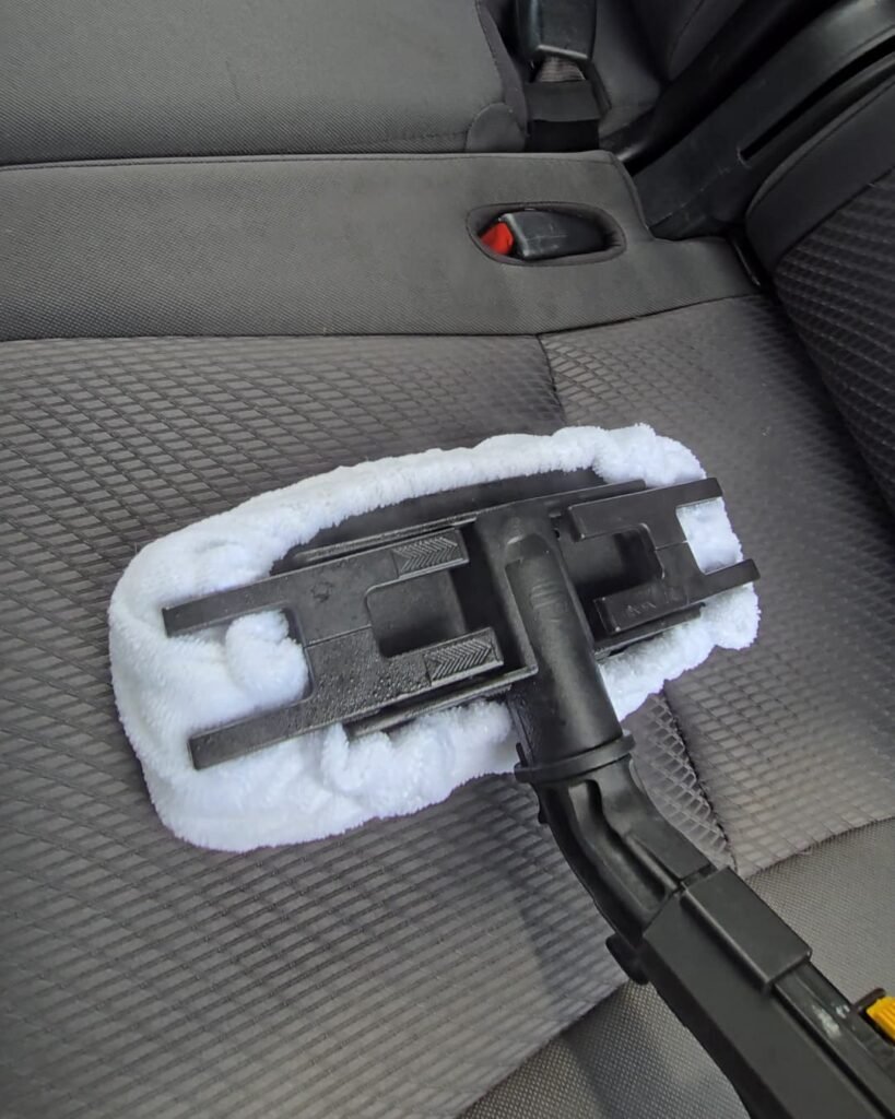 Steam interior cleaning as part of Premium Interior Detail service removing stains and embedded dirt from car seats